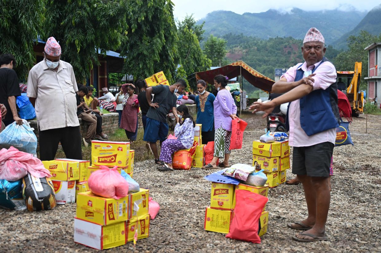 Flash flood survivors gather to receive utility aid from a temporary relief camp at Devighat in Nepal's Nuwakot district on September 3, 2026. Catastrophic floods on the China-Nepal border have killed at least 1,252 people in Nepal, the disaster authority said on Sept 3. - Photo: AFP