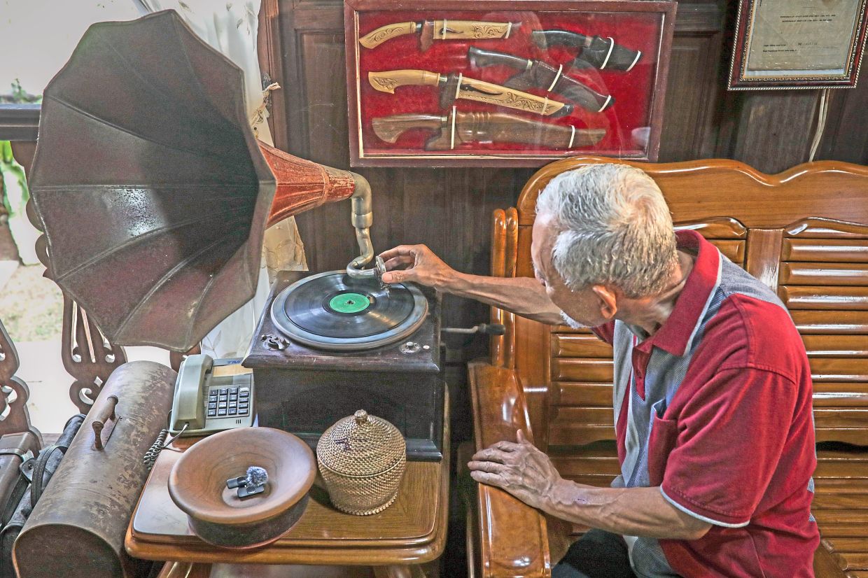 Mohamad Jusoh demonstrating one of the functioning antique gramophones displayed at his Perlis home.
