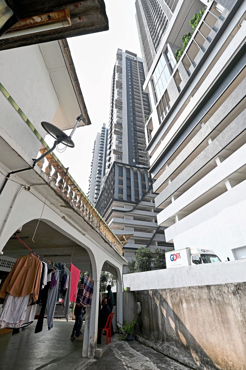 The high-rise development is metres from a house in Taman Tan Yew Lai.