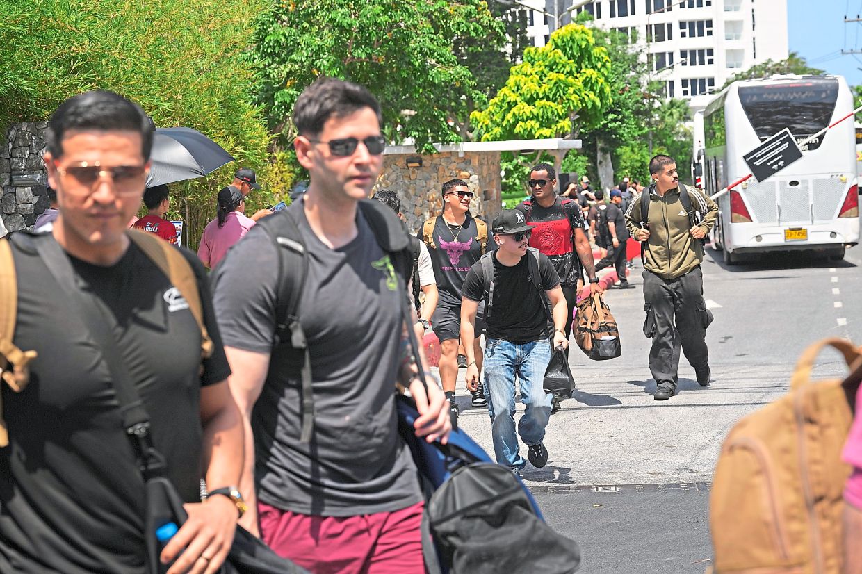 Crew members of the vessel leaving a hotel in Pattaya. —AP