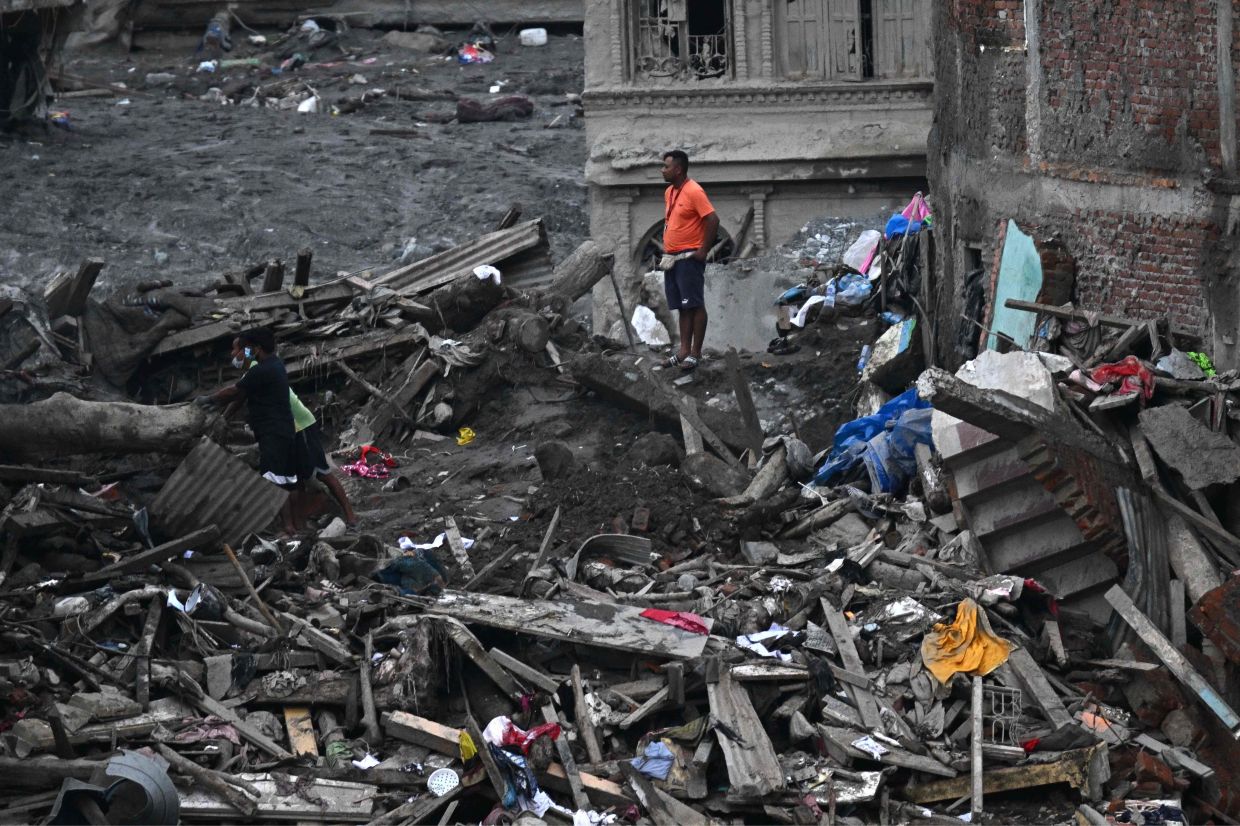 People clear debris in front of a damaged house covered in sludge in the aftermath of flash floods in Trishuli, Nepal's Nuwakot district on September 4, 2026. Devastating floods on the China-Nepal border have killed at least 1,287 people in Nepal, the disaster authority said September 4, with the number of missing at 5,083.- Photo: AFP