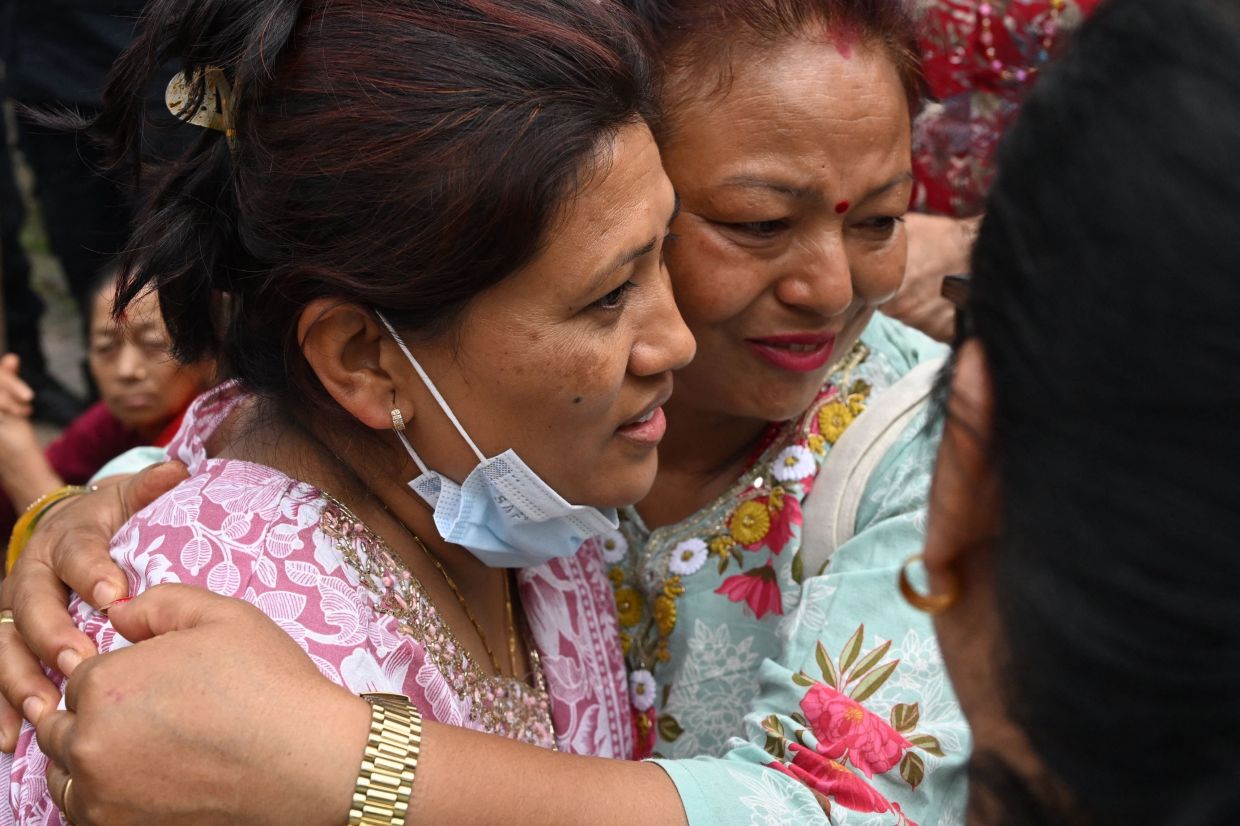 Trishuli-3A Hydropower Project's rescued worker Kabir Maharjan's wife Hirashova Maharjan (left) embraces a family member after visiting him at Chhauni Army Hospital in Kathmandu on Sept 4, 2026. Two hydropower workers were pulled from a tunnel buried by debris in Nepal on Sept 4, more than a week after catastrophic flooding swept through the area, government ministers said. - Photo: AFP