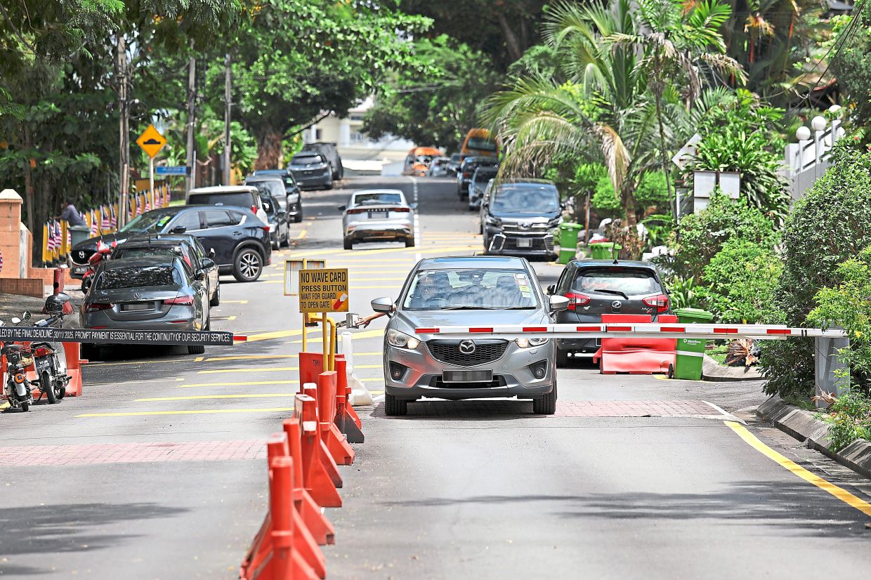 A vehicle passing through a guarded neighbourhood boom gate in Taman Desa Phase 1 where a dispute has occurred. — Filepic