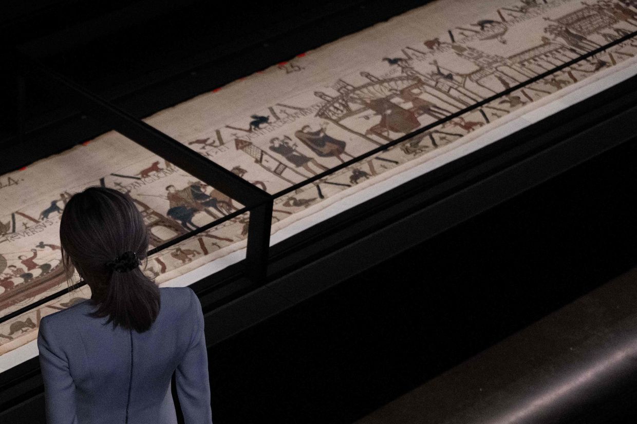 French President's wife Brigitte Macron gets a closer view of the Bayeux Tapestry during a preview event at the British Museum in London on Sept 2. Photo: AFP 