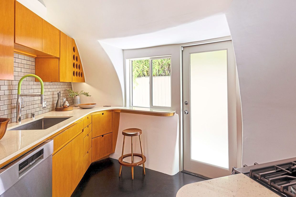 The modification of an interior wall altered the original curvy concept inside, but a restoration effort brought some of those curves back, especially in the kitchen.
