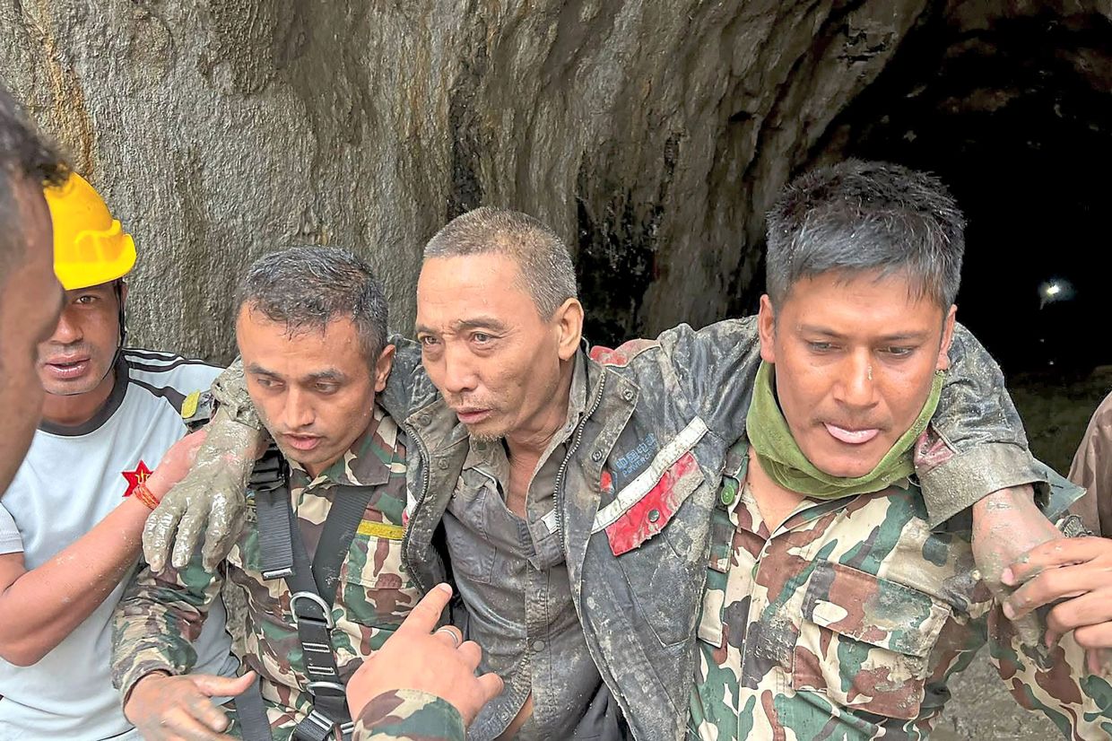 Security personnel carrying Luhaitao, who was rescued from the Upper Trishuli-1 Hydropower Project site. — AFP