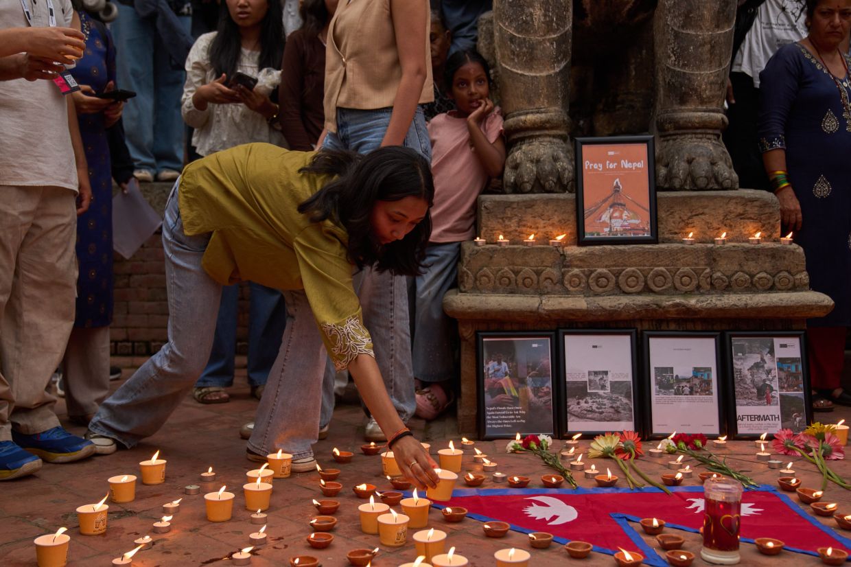 A Nepali girl places a candle on the ground during a candlelight vigil for victims of the floods in Nepal and Tibet, at Durbar Square in Kathmandu, Nepal, on Saturday, Sept. 5, 2026. -- AP Photo/Dar Yasin