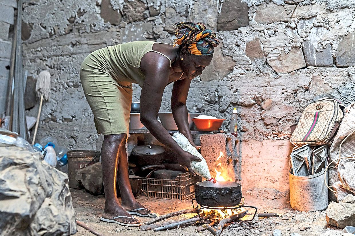 Tavares cooks at her home before going to the beach to mine sand for commercial sale.
