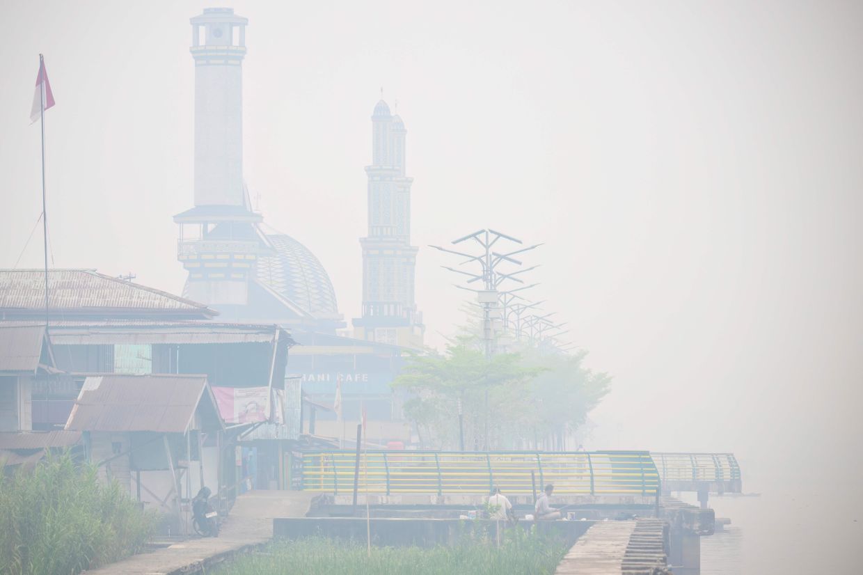Anglers fish by the Kapuas river as thick smoke and haze shrouds the city of Pontianak in West Kalimantan on Sunday, September 6, 2026. Indonesia has been battling for weeks to contain wildfires and thick smog, which has been drifting to Malaysia, Singapore and the Philippines. -- Photo by BAY ISMOYO / AFP