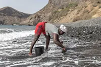Women sand miners toil stripped Cape Verde beach
