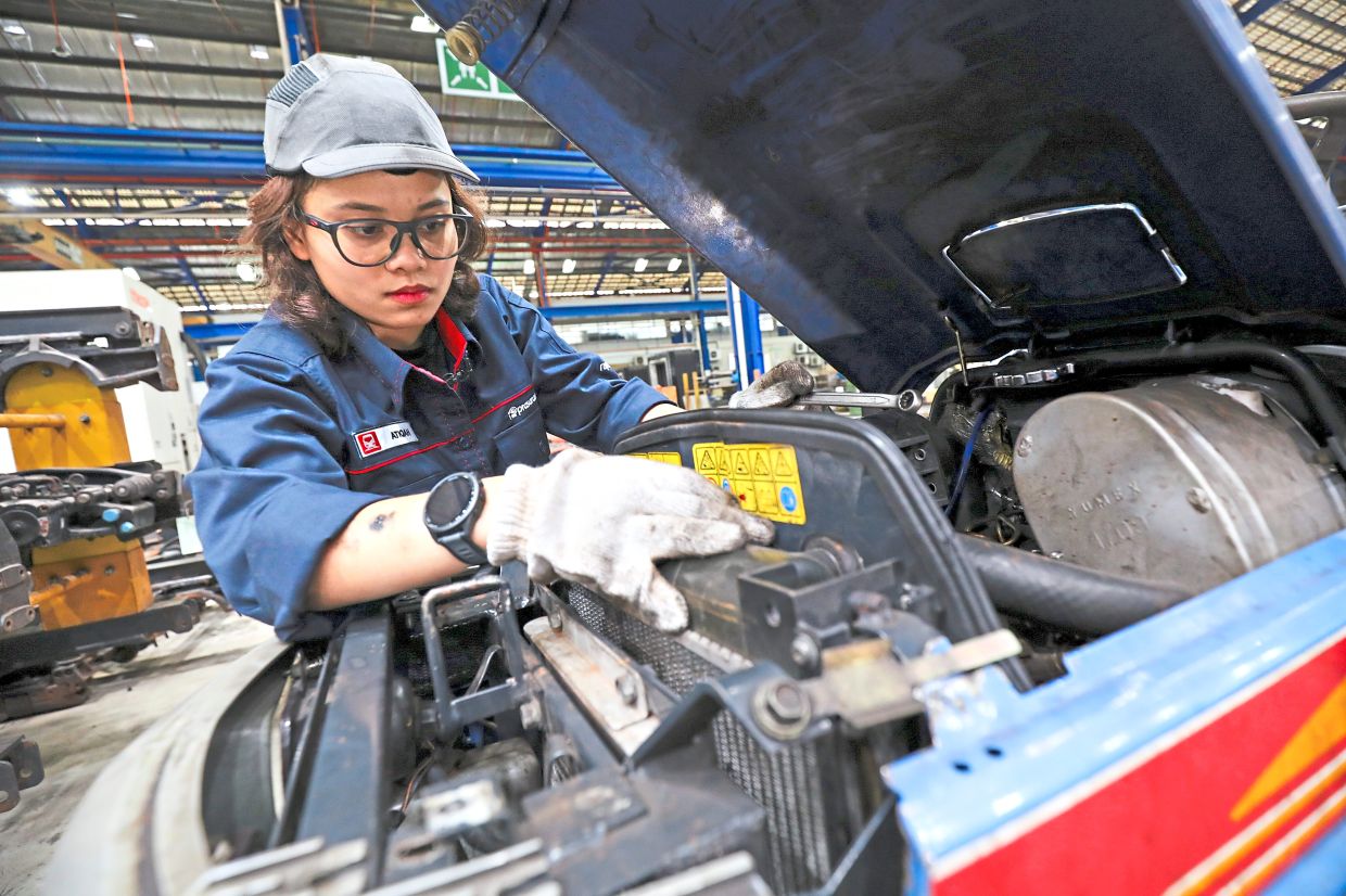 Busy at work: Nur Atiqah says people advised her to take on a desk job, but she prefers fixing things with her hands. — LEONG WAI YEE/The Star