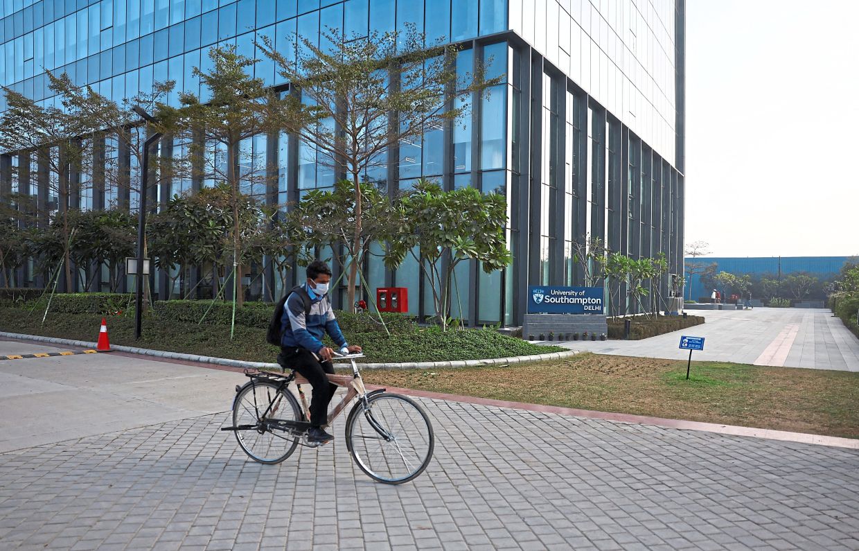 A man on a cycle (right) passing by the university building. — Reuters 