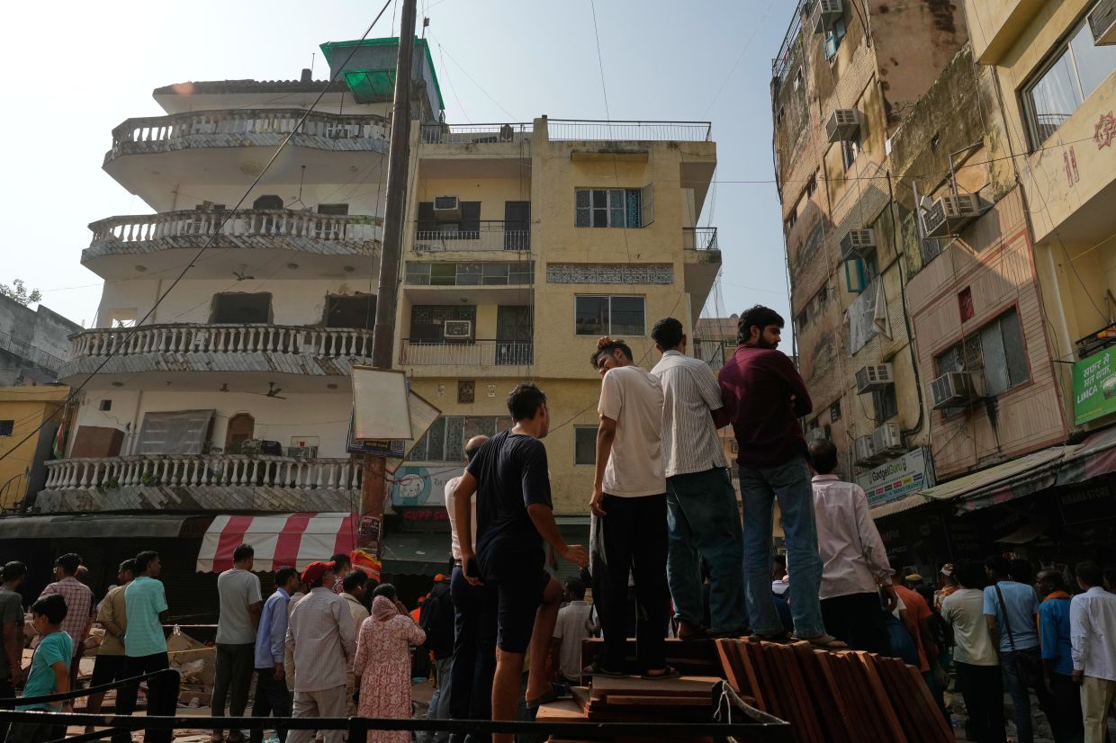 People watch as rescuers clear debris at the site of a collapsed building in New Delhi, India, Monday, Sept 7, 2026. - Photo: AP