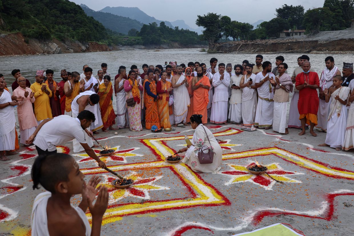 Hindu devotees pray along a riverbank in memory of the victims following flash floods and a mudslide, in Devighat, Nuwakot district, Nepal, on Monday, September 7, 2026. -- Photos: REUTERS/Tyrone Siu