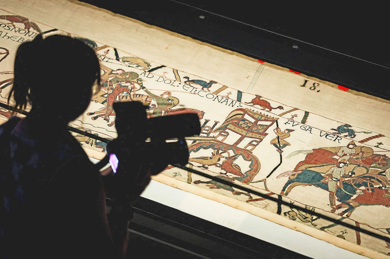 A camera operator videos a section of the Bayeux Tapestry during a preview at the British Museum in London on Sept 7. Photo: AFP 