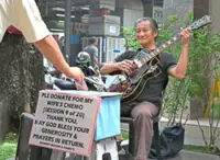 Blind busker strums for cancer-stricken wife