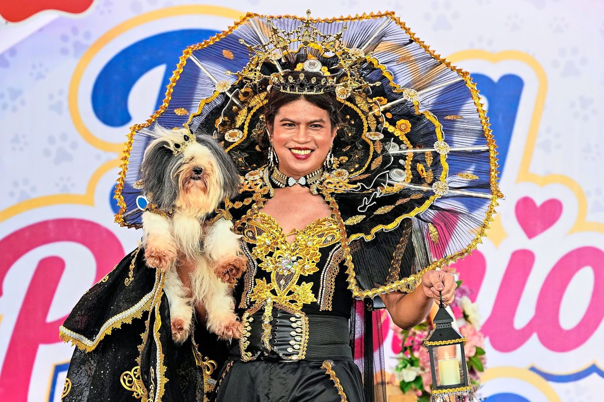 2. A dog and its owner steal the runway in matching elaborate costumes, strutting in style at the Dog Pawshion Show in Manila. — AP