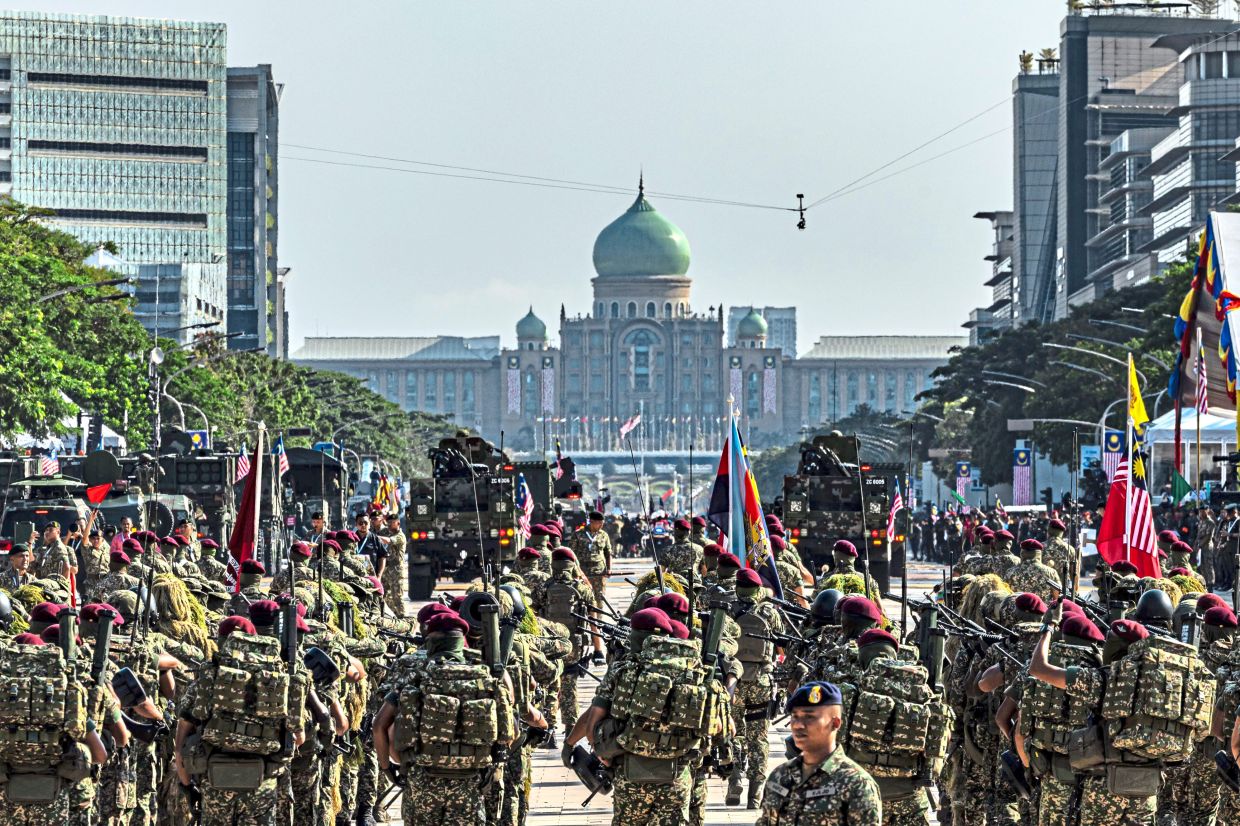 With flags flying and steps in unison, the Malaysian Armed Forces contingent marches into Putrajaya Square during the 2026 National Day celebration.