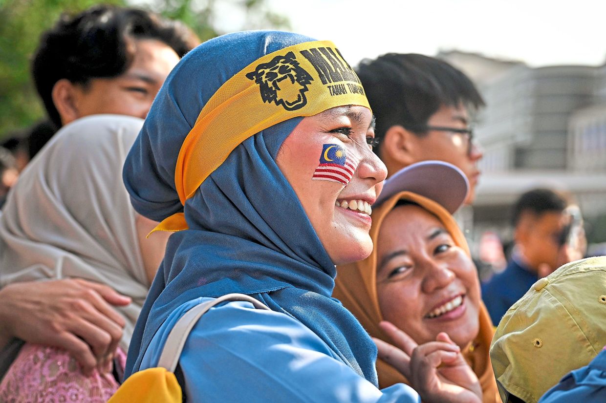 Women serve patriotic style as they pose for photographs during the 2026 National Day parade.