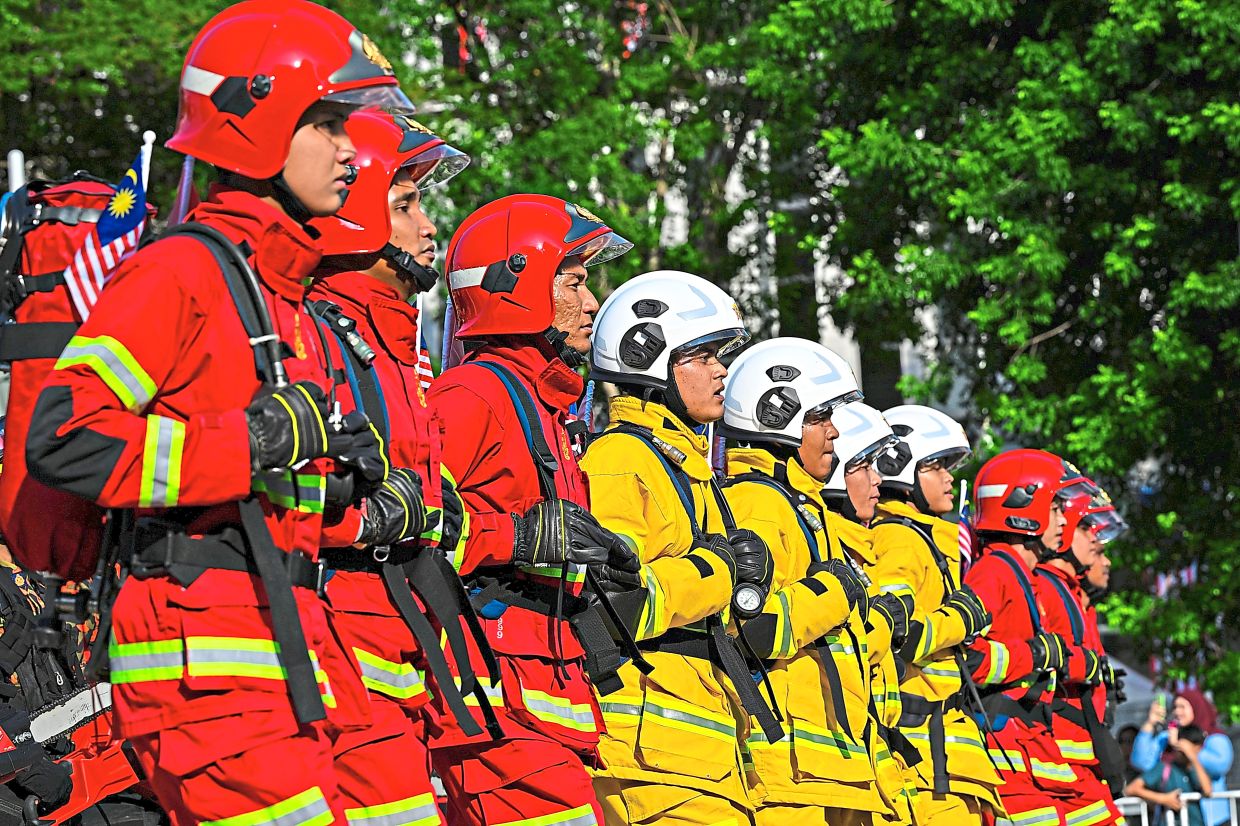 The Malaysian Fire and Rescue Department contingent marches in formation during the 2026 National Day celebration parade at Dataran Putrajaya.