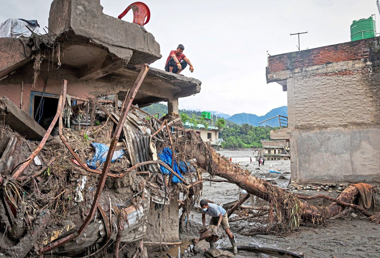 8. A man gathering his belongings from a home damaged by the flash floods. — Reuters