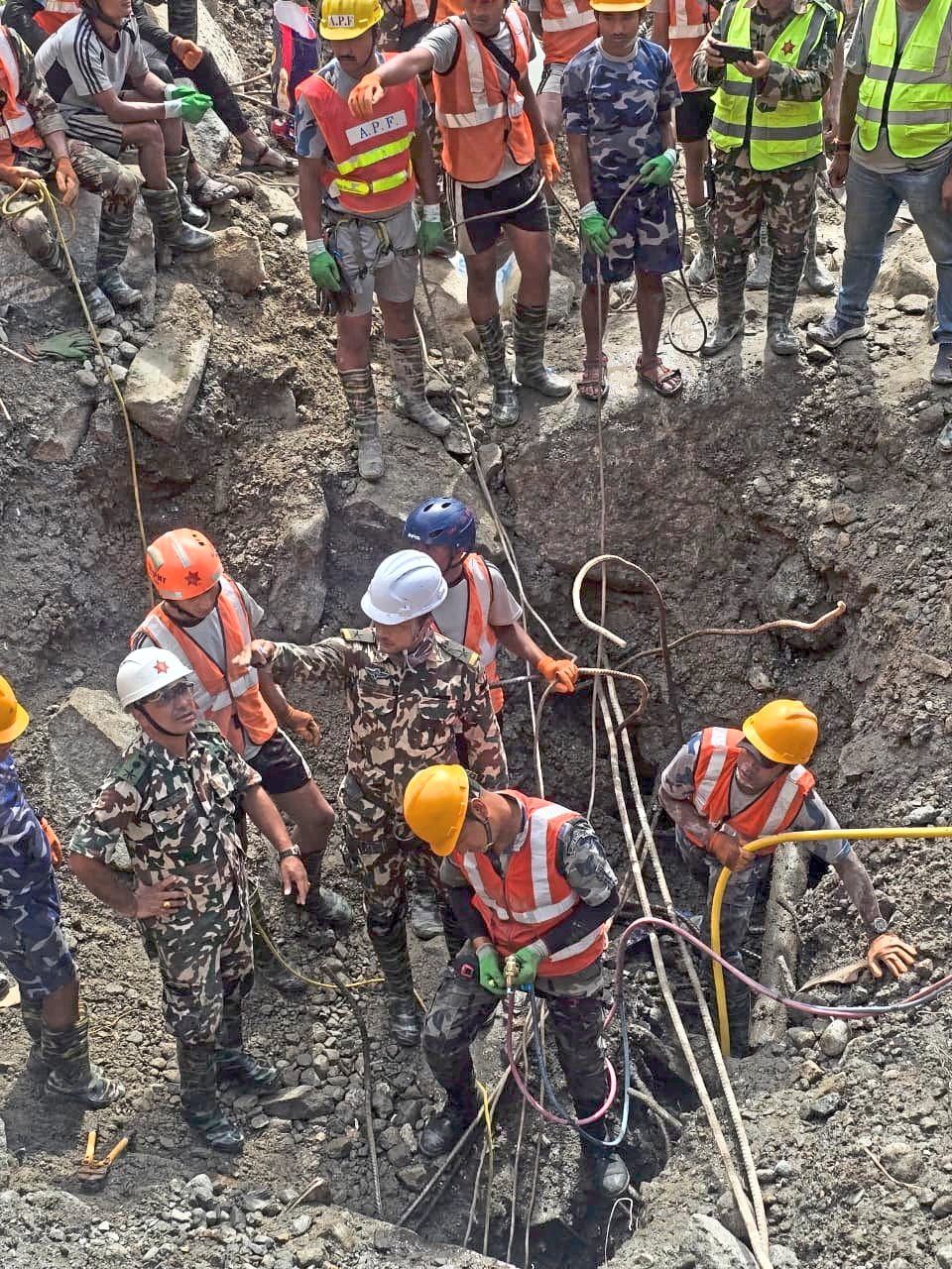 1. Members of a search-and-rescue team working to retrieve the body of a person, not pictured, who was trapped inside a tunnel at the Upper Trishuli-3A Hydropower Project after devastating floods and mudslides struck the Bhotekoshi River in Rasuwa. — APF Nepal/Reuters