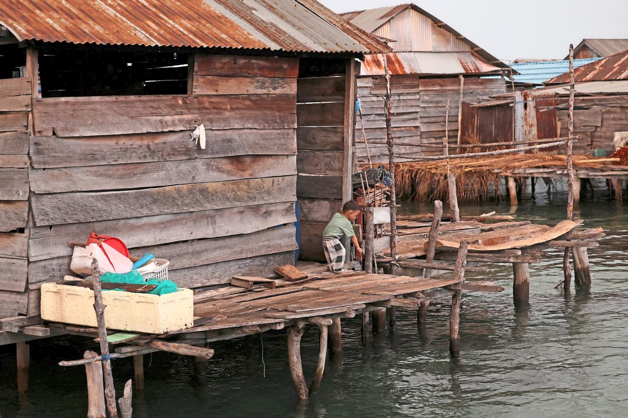 A child standing outside a wooden house in Torosiaje. — Reuters