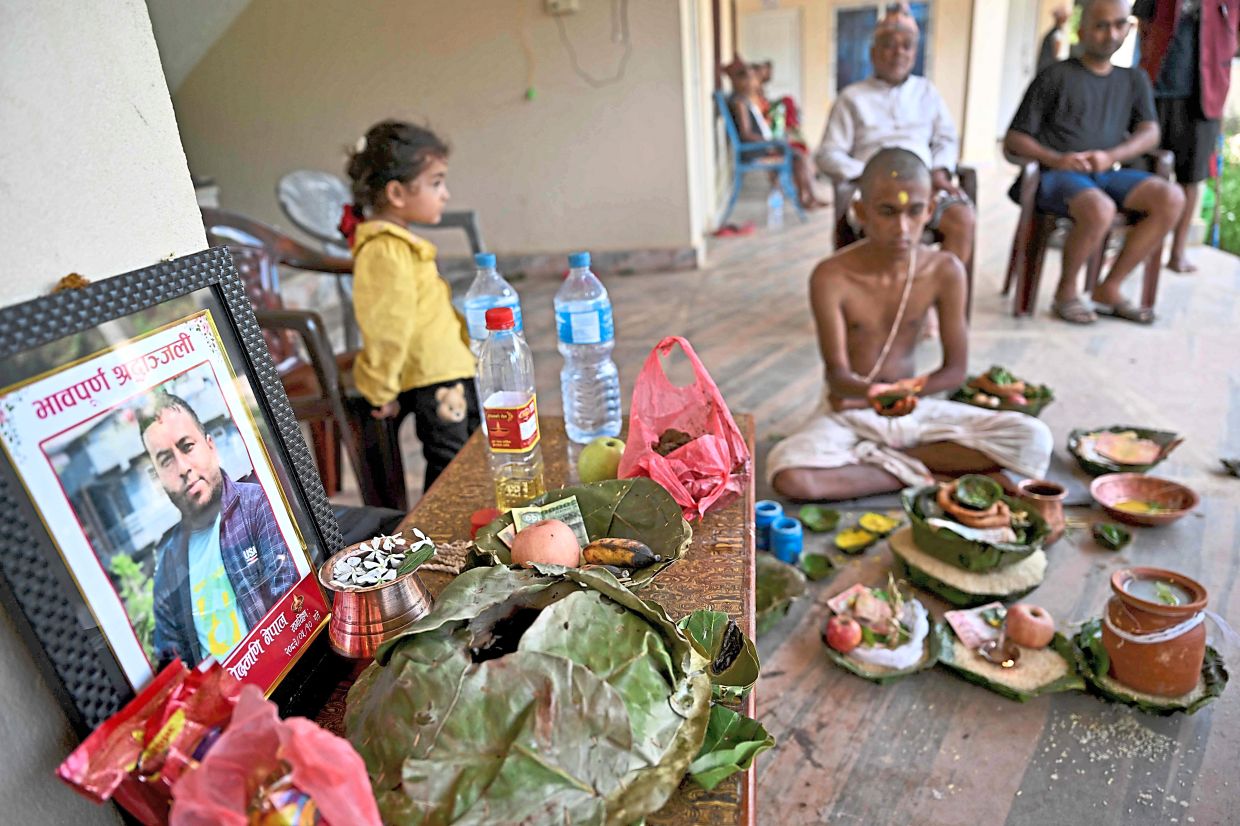 Gone too soon: Relatives of Moda Modi Nepa, 42, who was at the customs office on the Chinese border during the flash floods, taking part in Hindu funeral rites at Battar in Nepal’s Nuwakot. — AFP
