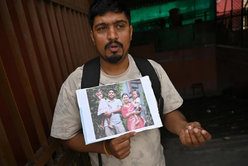 Sagar Poudel holding a family picture showing his cousin Somnath Poudel, an engineer who is missing in Trishuli 3B hydropower tunnel, his wife and twin daughters. - ST: DESMOND FOO