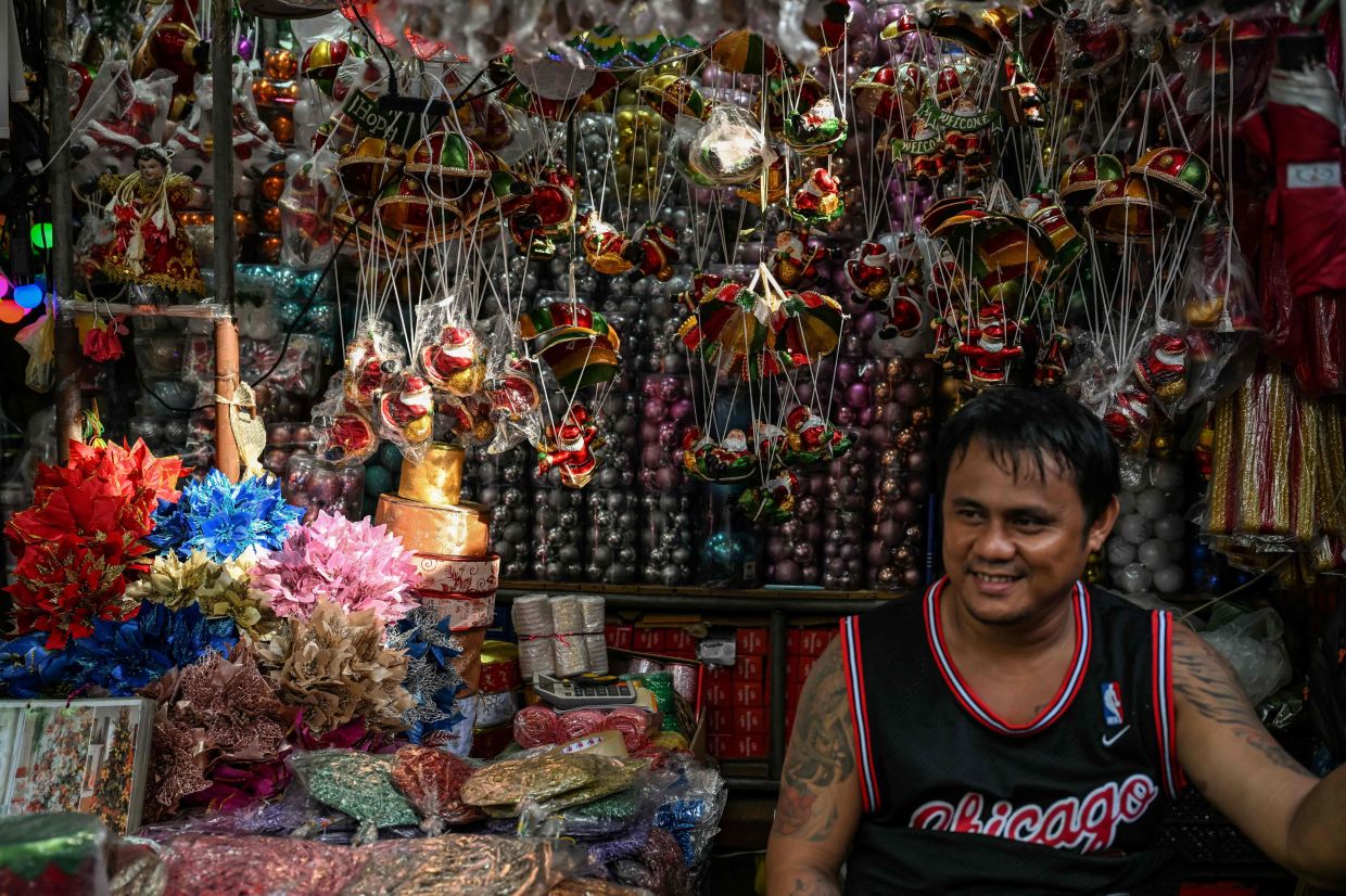 A vendor selling Christmas decorations at Divisoria market in Manila on Sept 1. - AFP