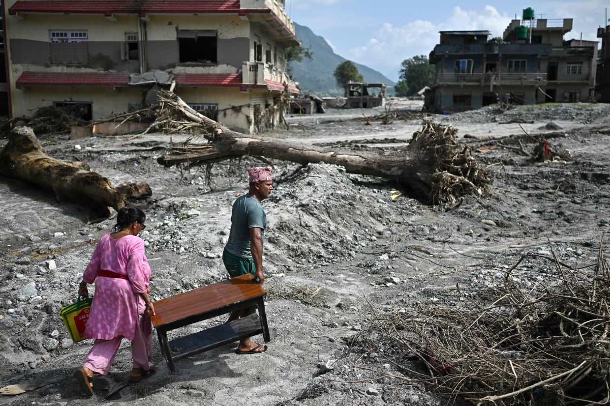 People recover their belongings in the aftermath of flash floods at Devighat in Nepal's Nuwakot district on September 8, 2026. The August 26 glacial and mountain collapse on the China-Nepal border killed at least 1,357, with 5,326 people still missing, including around 800 foreigners. - Photo: AFP