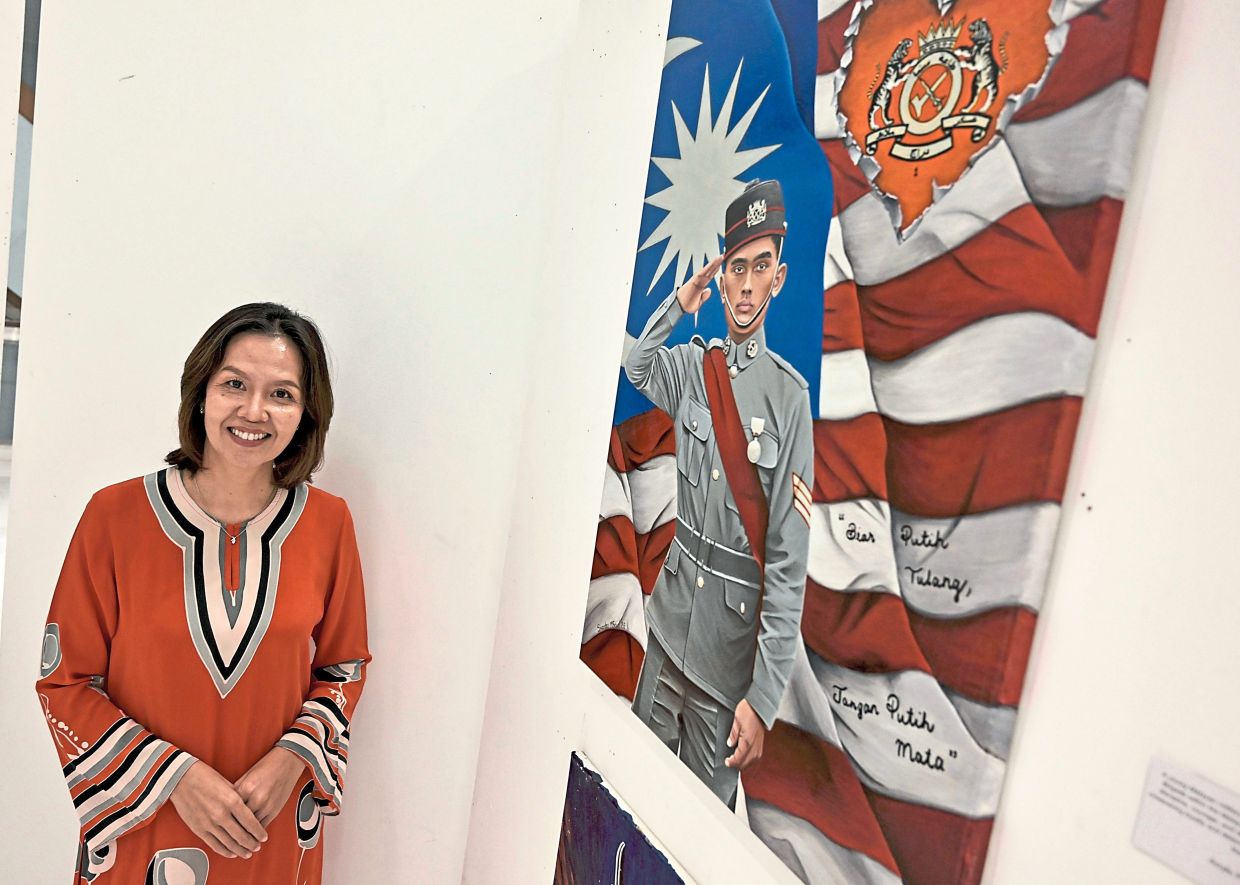Shasha with the portrait of national hero Leftenan Adnan Saidi during the Merdeka Art Exhibition at The Shoppes, Four Seasons Place, Kuala Lumpur.