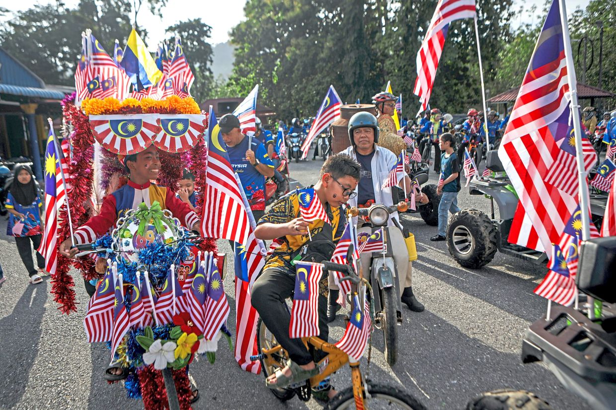 About 200 residents of Kampung Wang Kelian in Perlis taking part in a 8km convoy while flying the Jalur Gemilang in conjunction with National Day celebrations.