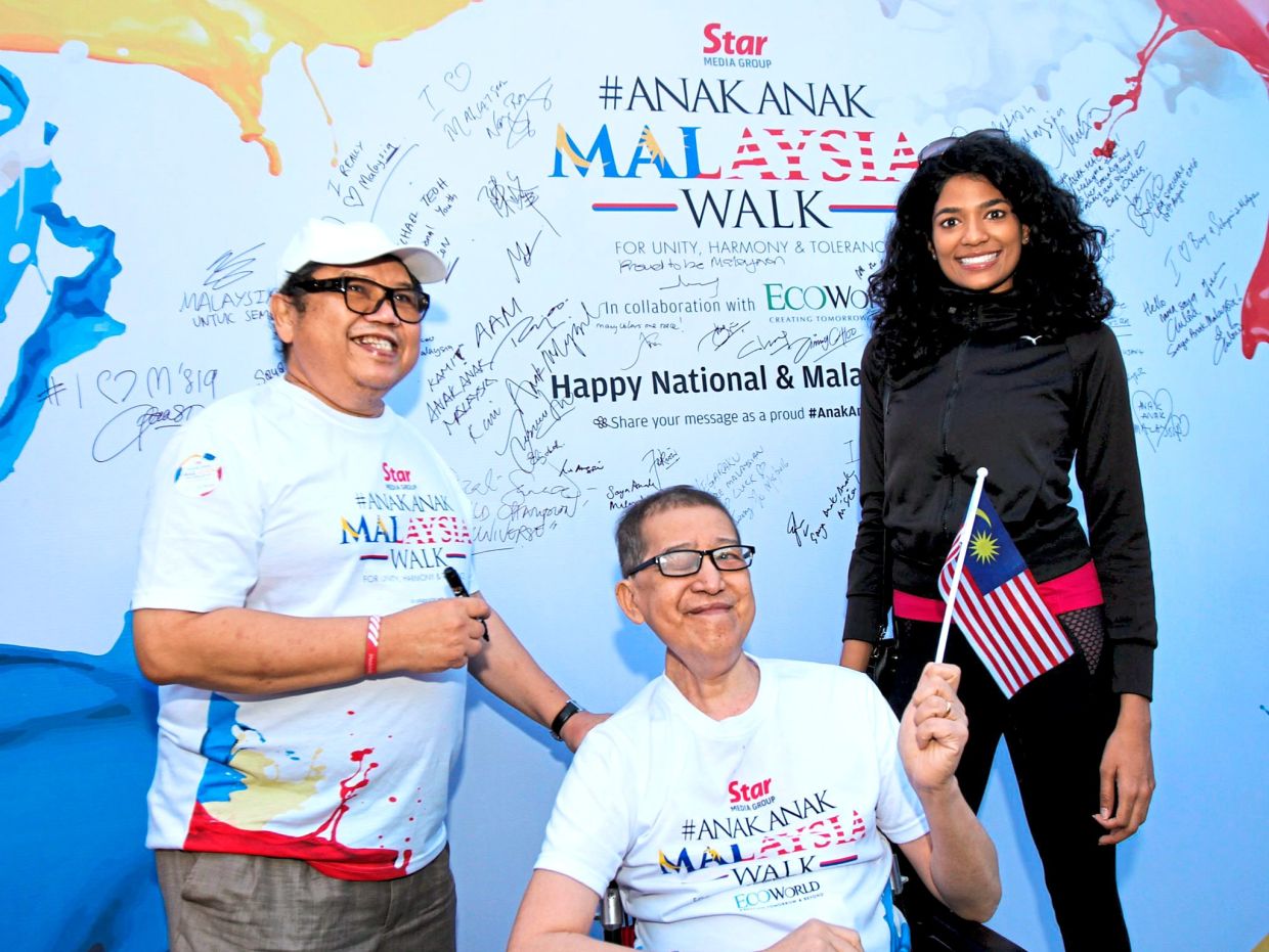 2016: (From left) Cartoonist Datuk Mohammad Nor Khalid, better known as Lat, with his friend the late Soo Ewe Jin, the then executive editor of The Star, and Miss Malaysia 2009 Thanuja Ananthan after signing on the AnakAnak Malaysia Walk 2016 display board. — Sam Tham/The Star