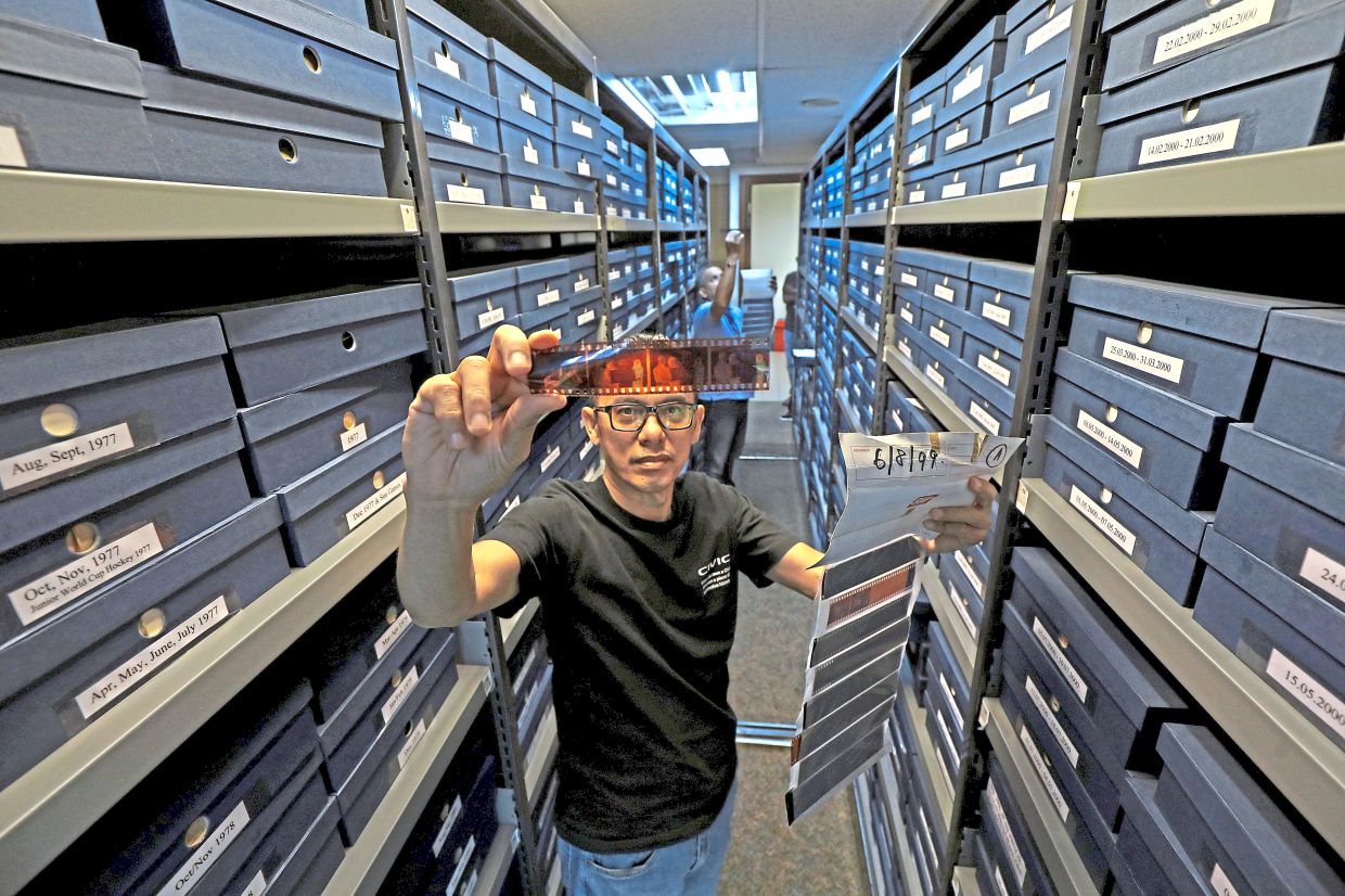 Aminuddin browsing photographic negatives preserved in The Star’s archive, documenting decades of Malaysia’s changing news landscape.