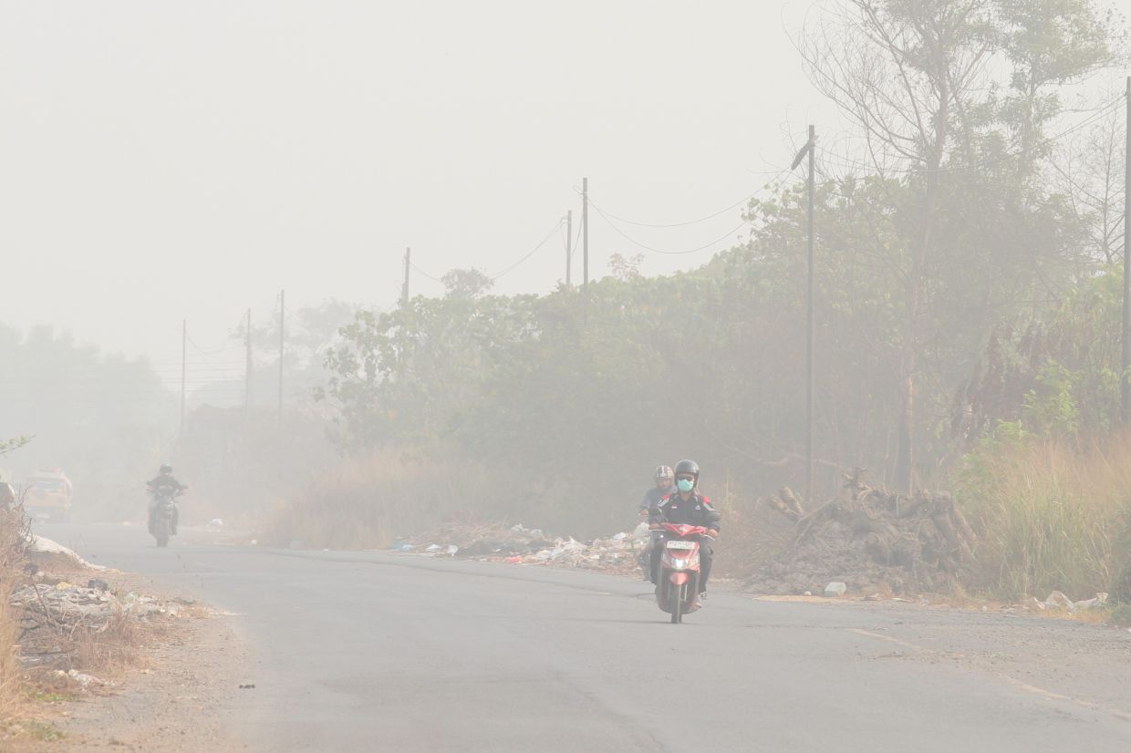 Motorists ride their two-wheelers on a road amid haze from wildfires in Palembang, South Sumatra, Indonesia, Wednesday, Sept. 9, 2026. - Photo: AP