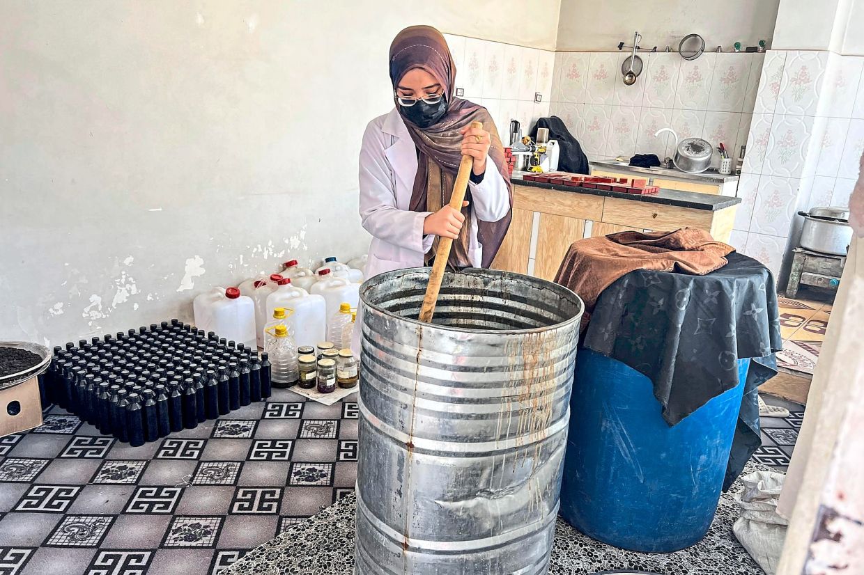 Ruqia makes shampoo in her soap workshop. Photo: Fardina Akbari/dpa