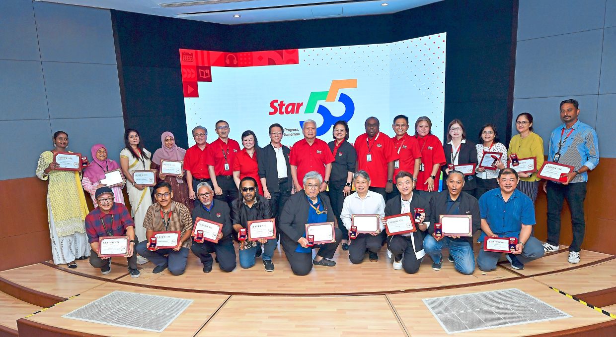Seasoned veterans: Staff with 25 years of service posing with their awards during the anniversary celebration. — AZHAR MAHFOF/The Star