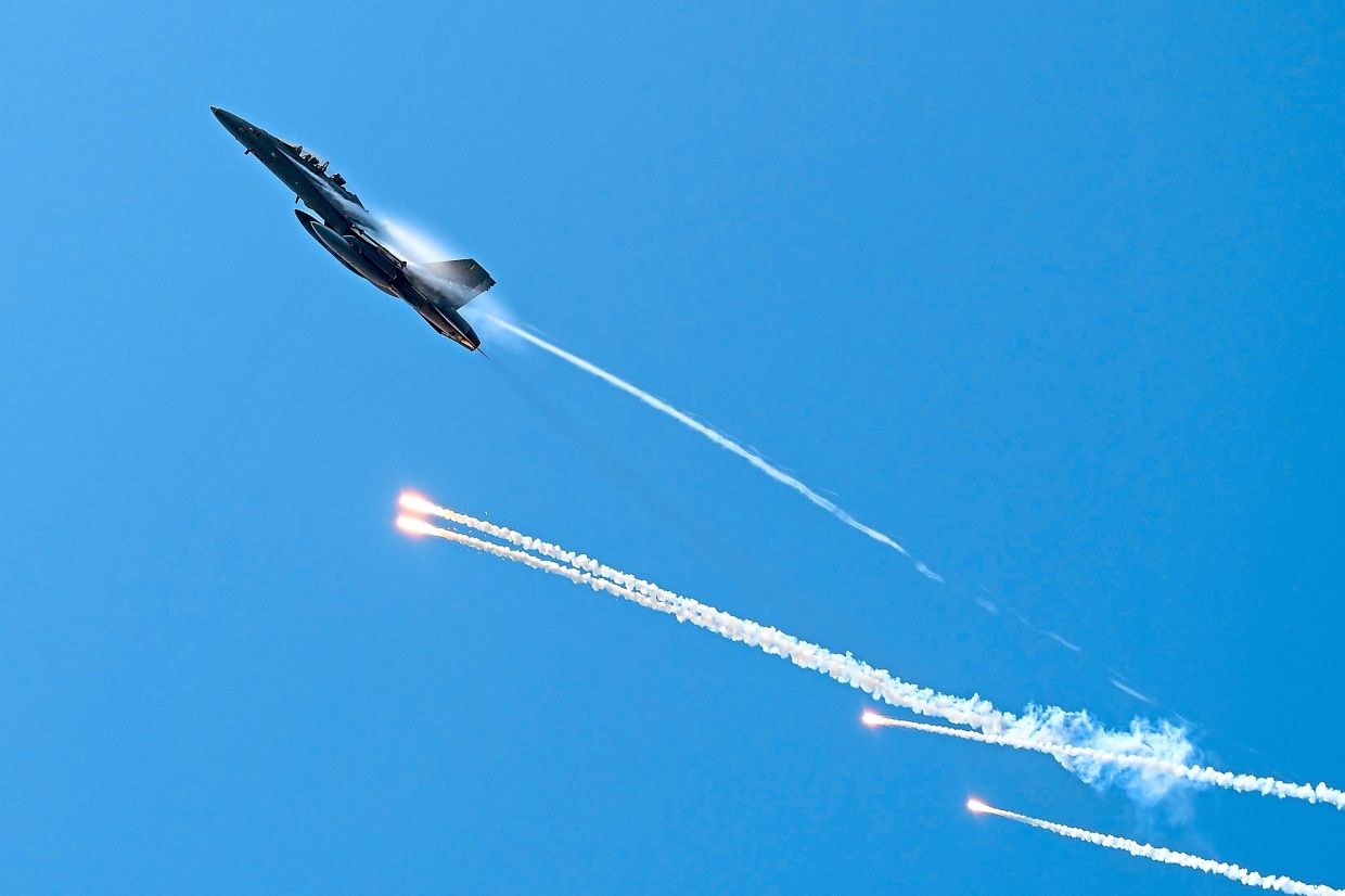 An RMAF fighter deploys flares during a dramatic flypast.