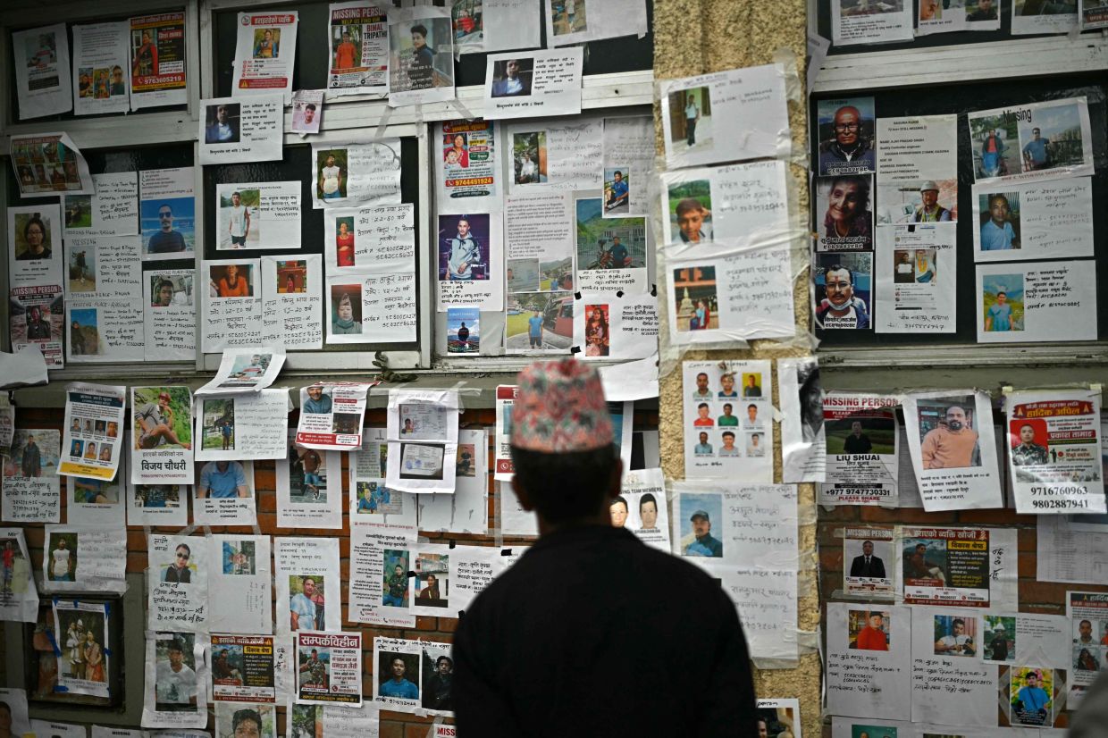 A man looks at photographs of missing persons outside a morgue in the aftermath of flash floods in Kathmandu on Sept 9, 2026. The Aug 26 tsunami-like surge of water, mud and debris, which began on the China-Nepal border, has killed more than 1,420 people and left 5,649 missing. - Photo: AFP