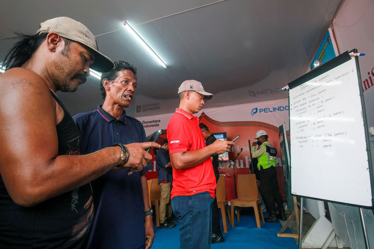 Families members of affected passengers read updates on a whiteboard on ongoing rescue operations on the stricken Virgo Transport 8 ferry, at Trisakti Bandarmasih Port in Banjarmasin, South Kalimantan, on Sept 13, 2026. One person died, and more than 100 were rescued Sept 13 from a ferry that ran into bad weather in Indonesia while sailing north from Java to Borneo, rescue officials said. - Photo: AFP