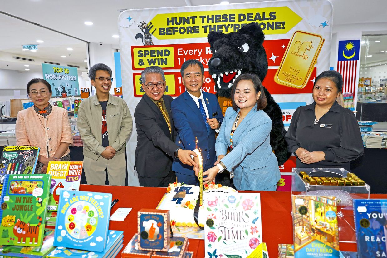 (From third left) Japri, Hii and Lim cutting a cake to launch the Big Bad Wolf book sale in Kuching.