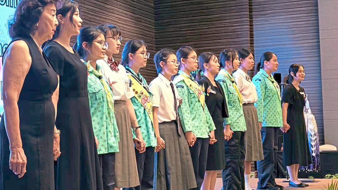Japanese high school students and students from Yu Yuan Secondary School standing hand in hand as they perform together during a dinner ahead of Sandakan Memorial Day.