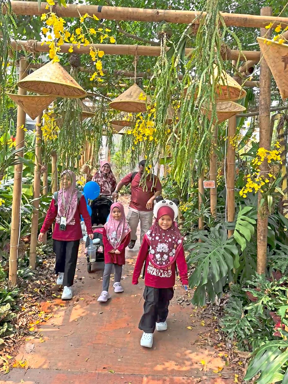 Woven farmers’ hats and hanging tassel ferns lend a cool, green canopy for visitors to the Federal Territories Pavilion.
