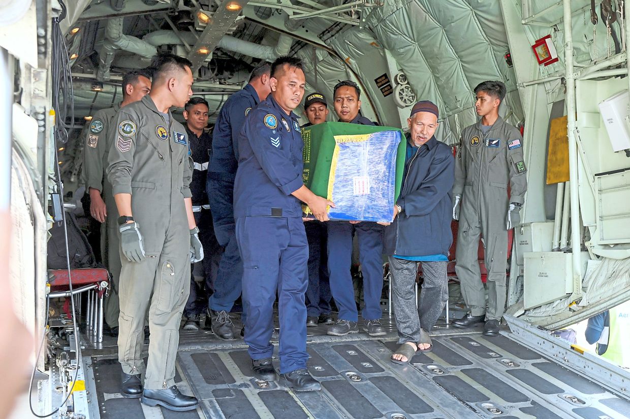 Sorrowful farewell: A Royal Malaysian Air Force special aircraft carrying the remains of Dr Ainul Baraah arriving at Sultan Ismail Petra Airport, Pengkalan Chepa, Kelantan; (below) colleagues and family members paying their final respects to Debra’s remains in Kampung Semadang, Padawan, Sarawak. — Bernama