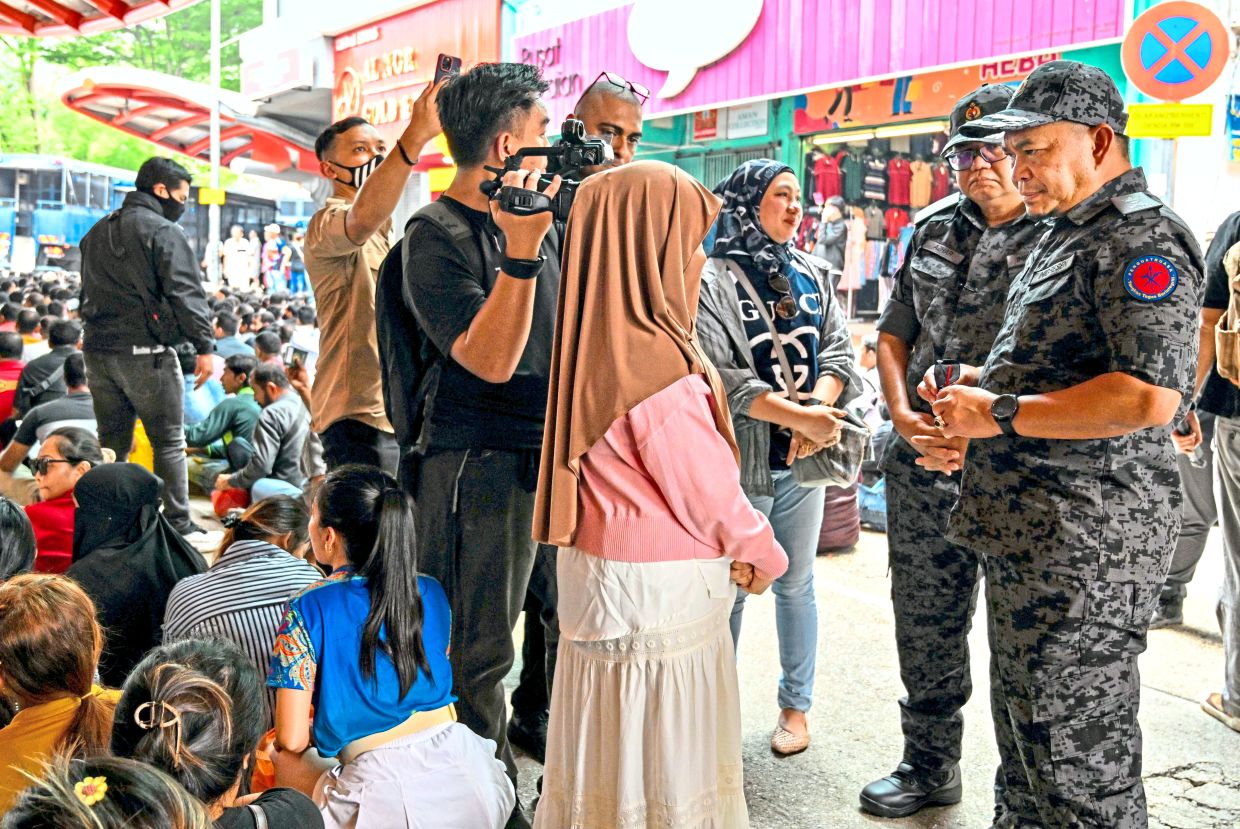 No room for rule breakers: Hamsha (right) overseeing the operation by the Immigration Department which saw checks conducted upon foreign nationals at Jalan Silang, Kuala Lumpur. — Bernama