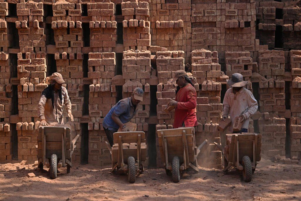 Migrant labourers at a brick kiln on the outskirts of Srinagar. Despite tough working conditions, they say they can earn much more than they could at home. - Photo: AFP