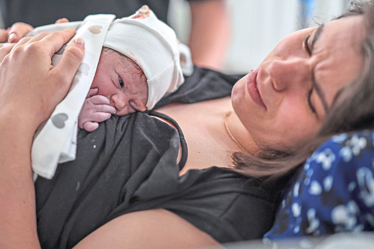 Ischuk holding on to her newborn son Yaroslav as drone strikes continue in Kyiv.