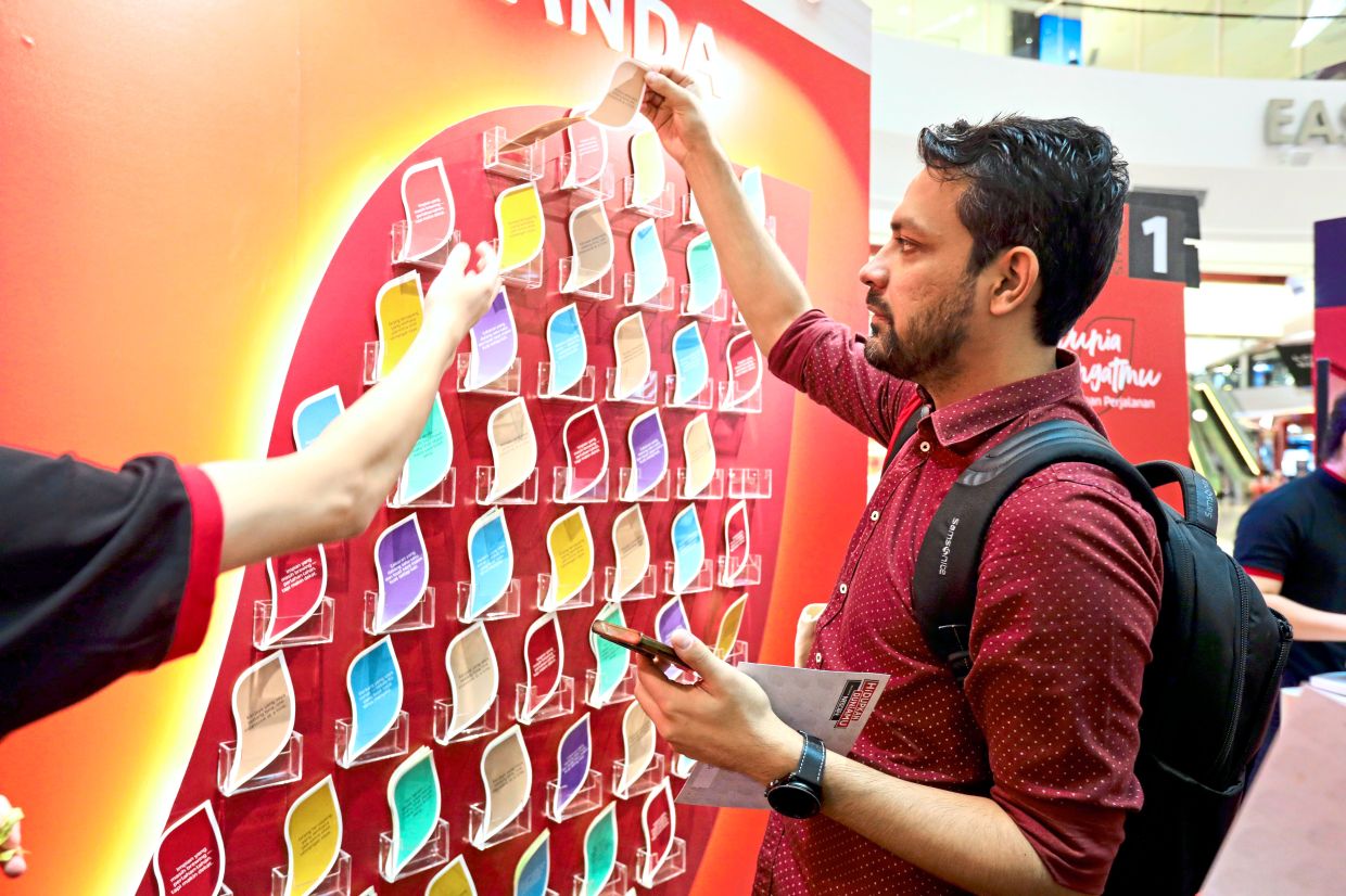An eventgoer customises their activity card with an inspirational quote as part of the interactive activity.