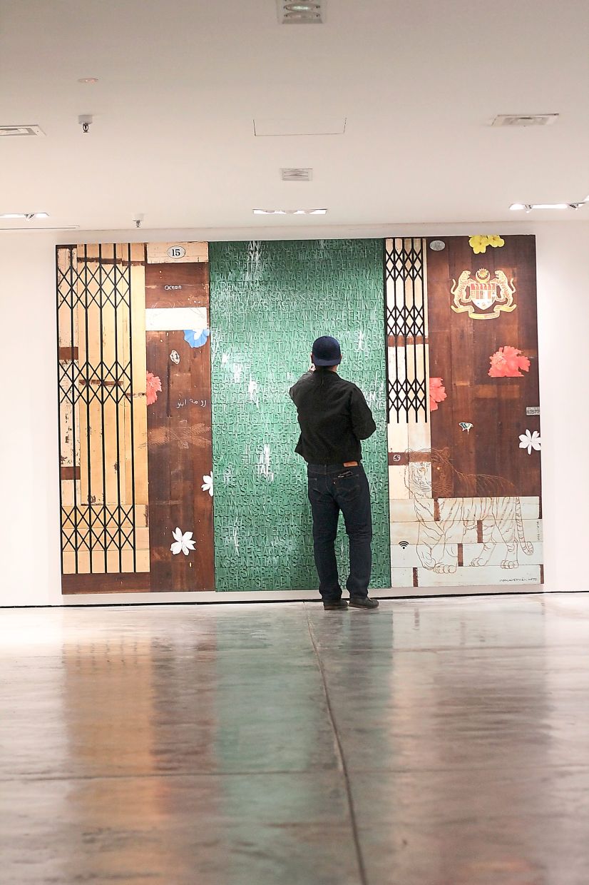 A gallery visitor views the striking scale of Shukri’s 'Rumah Ibu', a highlight of his 'IlmuAdab' exhibition at Sareng Gallery in Kuala Lumpur. Photo: The Star/M. Irsyad 